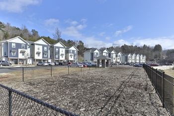 A row of houses with a fence in front.